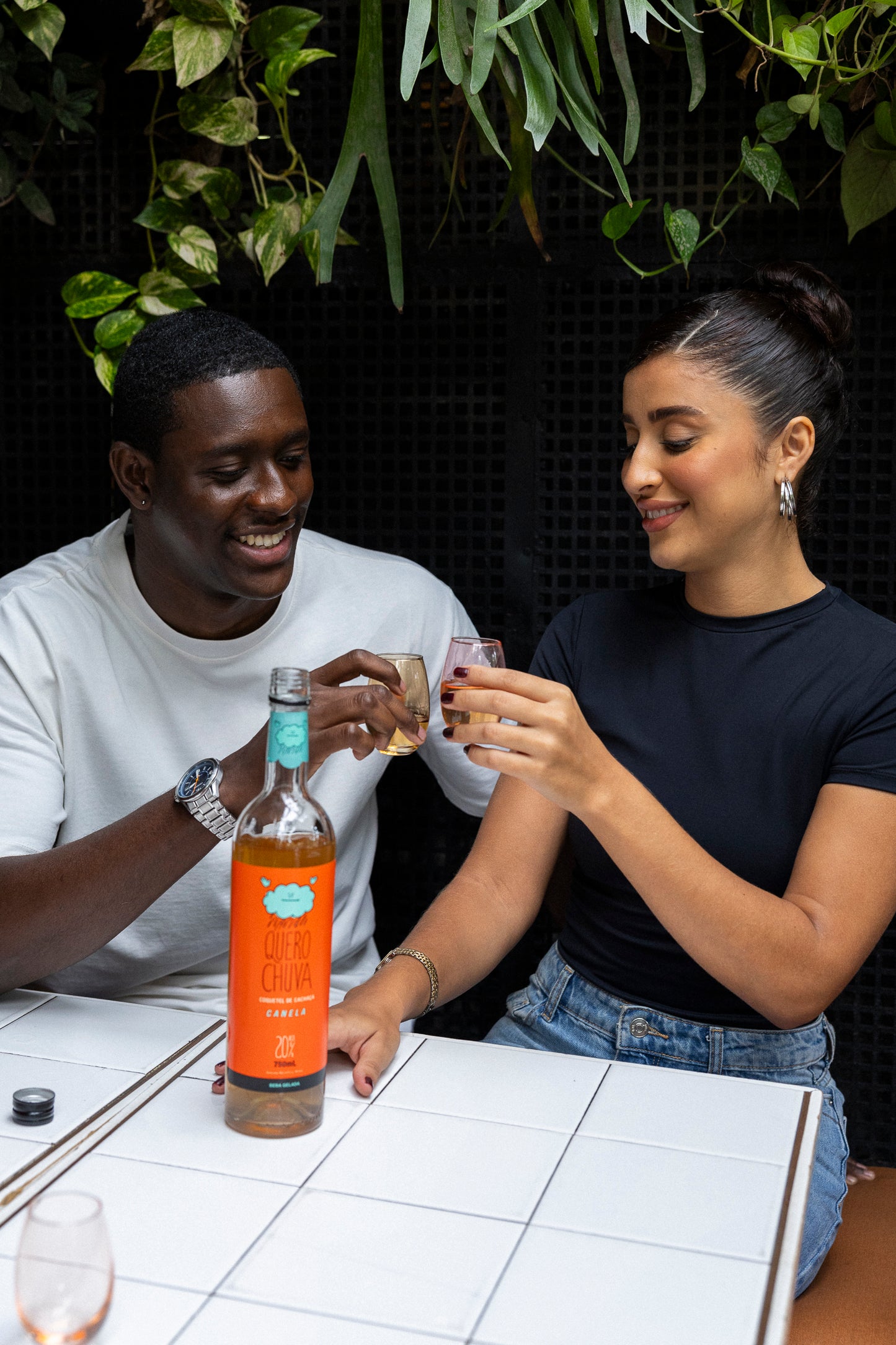 Quero Chuva Canela 750 ml na mesa branca com amigos — pronta para beber