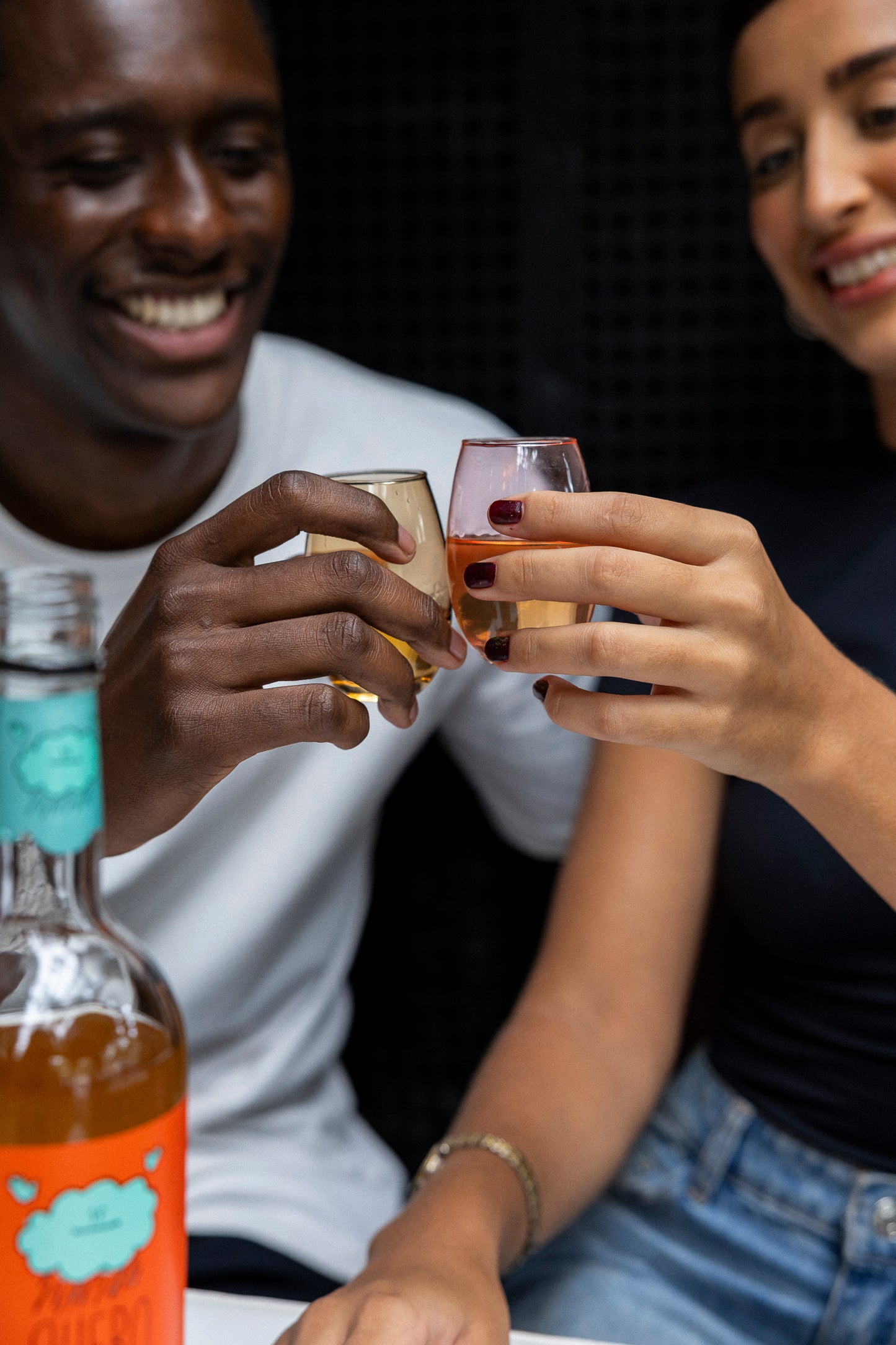 Mãos brindando com Quero Chuva Canela — close dos copos