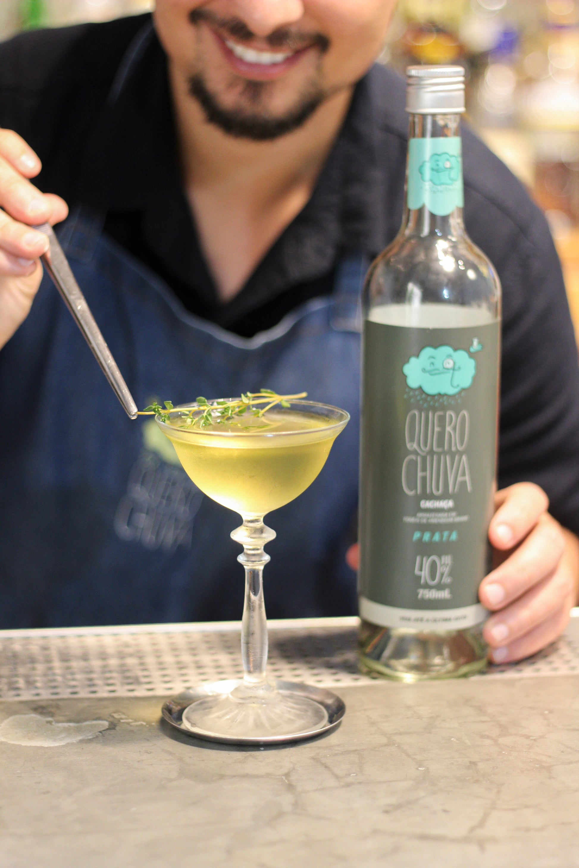 Bartender preparando coquetel com Quero Chuva Prata no balcão