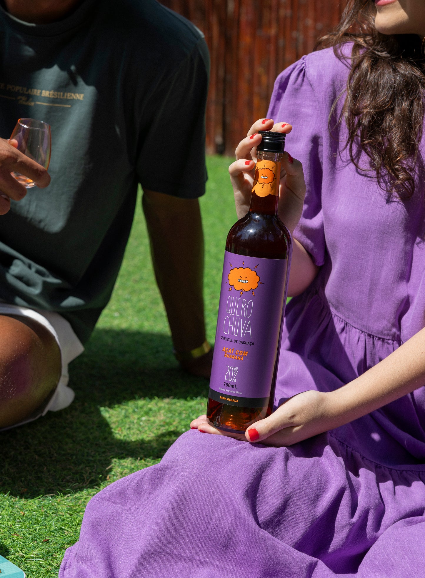 Quero Chuva Açaí com Guaraná 750 ml nas mãos — pessoas de roxo ao ar livre