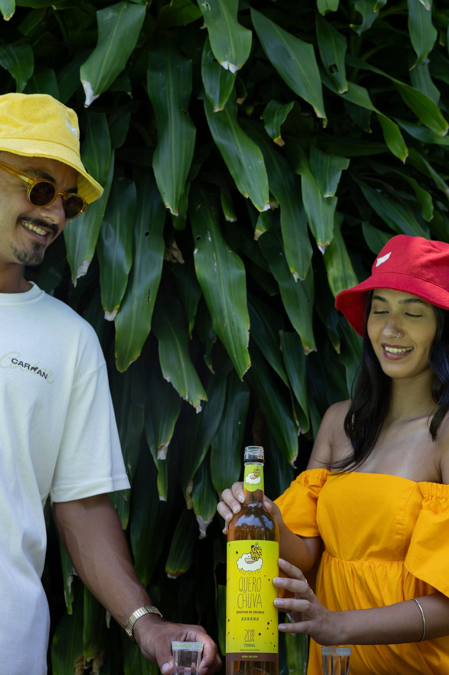 Brinde com Quero Chuva Banana — duas pessoas servindo dose gelada