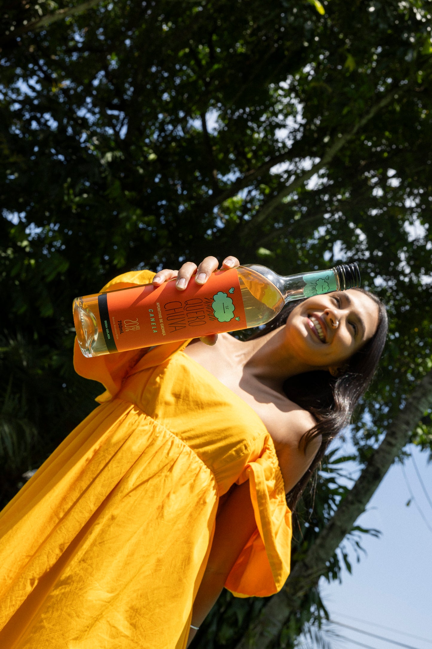 Pessoa de amarelo servindo Quero Chuva Canela ao ar livre — dose gelada
