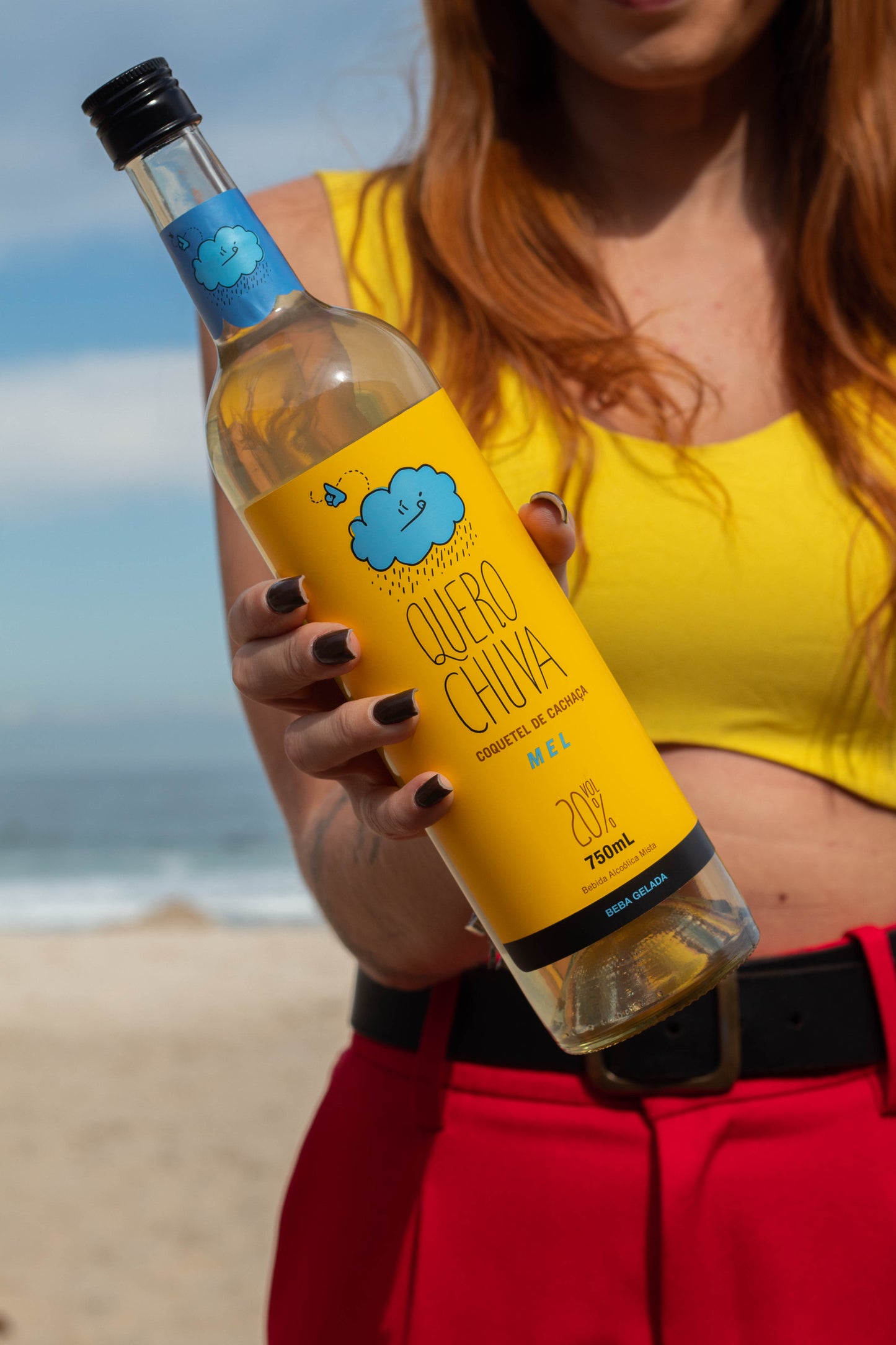 Pessoa segurando Quero Chuva Mel 750 ml — close na cintura