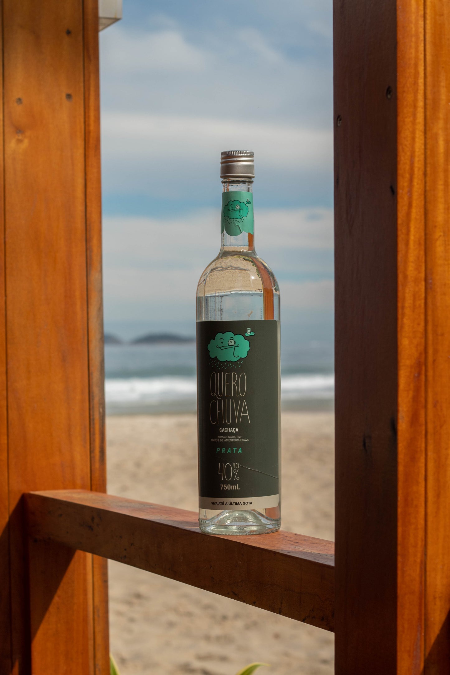 Quero Chuva Prata 750 ml na praia com o mar ao fundo